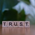 Scrabble tiles spelling the word Trust, symbolizing how to earn trust and respect